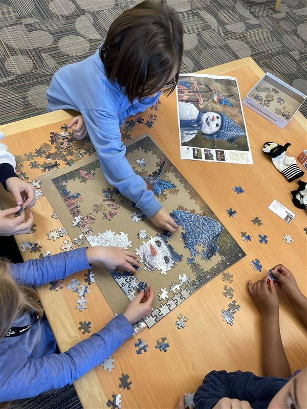 Students work together to complete a snowman puzzle